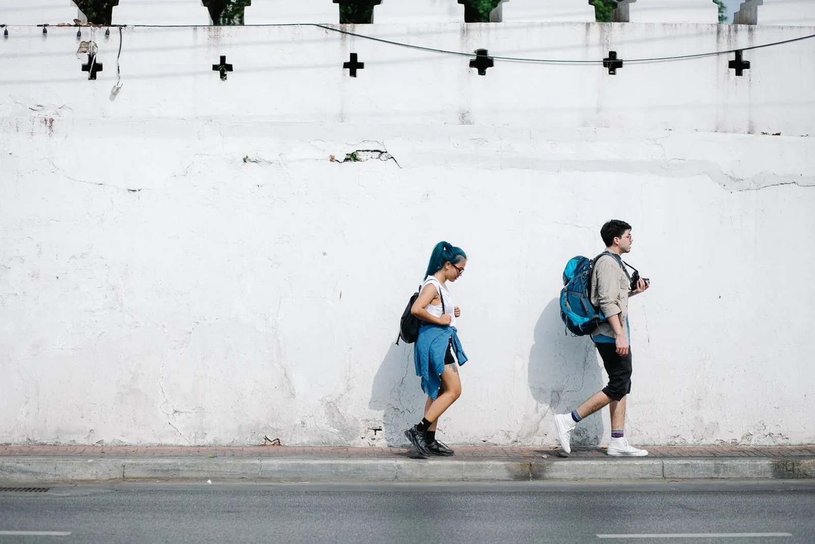 Two young adults with backpacks walking through a city